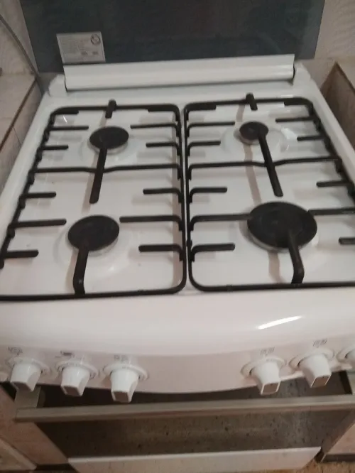 Cuisinière de couleur blanche avec four et 04 feux, très trés peu utilisée.