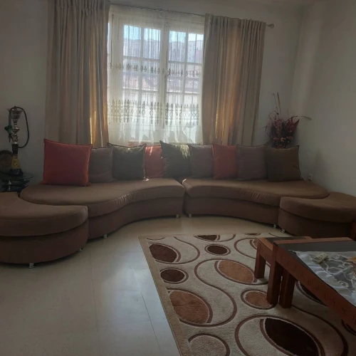 À VENDRE  Salon incurvé en tissu anti-tâches + poufs et coussins  Très bon état